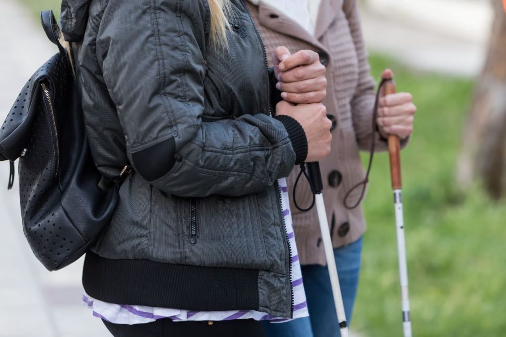 deux personnes qui se déplacent avec une canne blanche