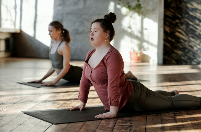 Jeune femme atteinte de trisomie 21 faisant du handi-yoga.