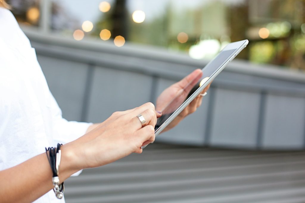 un apprenant tient une tablette pour suivre la formation DEAES