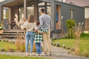 une famille est devant la maison qu'ils souhaitent acheter grâce à un prêt immobilier