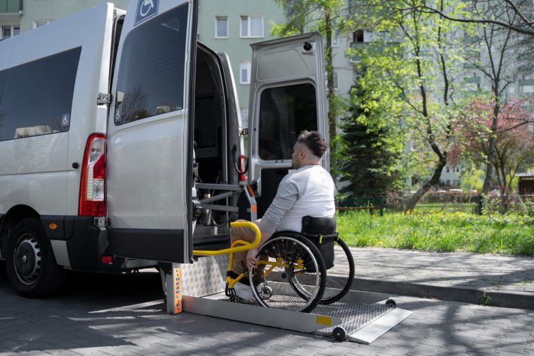 une personne en fauteuil roulant monte dans un véhicule adapté au transport des personnes en fauteuil roulant