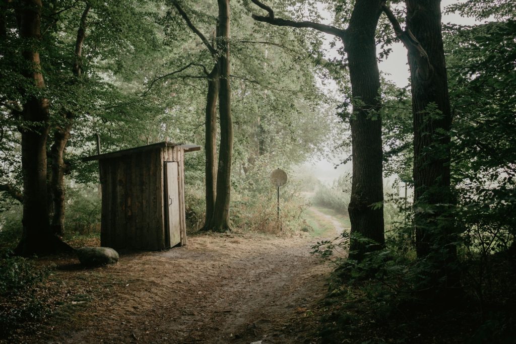 une cabane enbois au milieu des bois. Toilettes en pleine nature - incontinence urinaire invalidité